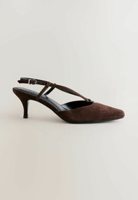 Zapato slingback de ante marrón con punta en forma de pico, delgada correa en el tobillo y tacón de aguja de 2.5 pulgadas. Cuenta con forro interior negro.