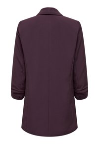 Purpura vidēja garuma jaka ar atloku apkakli, trīs ceturtdaļu piedurknēm un gludu tekstūru. Raksturīga tīra muguras šuve un uzlocītas piedurkņu aproces.