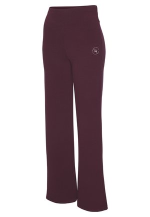 Gerippte, weite Hosen in einem tiefen Burgunderrot. Sie verfügen über einen taillierten Bund und ein kleines Logodetail auf der Vorderseite. Weiche Textur.