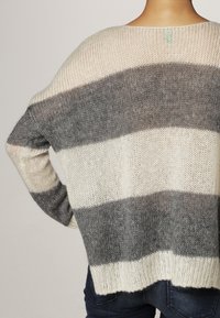 Tröja i bomullsblandning med horisontella ränder i kräm och grå nyanser, med en avslappnad passform och öppen stickning.