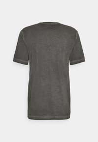 Grå T-shirt med kort ärm och rundad halsringning, tillverkad av ett mjukt, texturerat tyg; har en något avslappnad passform och synlig sömnad.