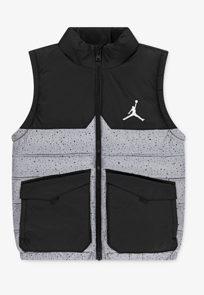 Veste sans manches matelassée avec le haut noir, la partie basse grise tachetée, poches avant noires, fermeture éclair et logo Jumpman blanc sur la poitrine.