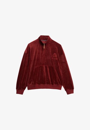 Bordeauxfarvet velour-pullover med høj krave, kvart lynlås og frontlomme; har broderet logo på brystet. Blød tekstur og afslappet pasform.