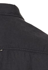 Zwarte shirt met een kraag, knoopsluiting en zichtbare stikseldetails. Het materiaal lijkt textuur te hebben en is licht van gewicht.