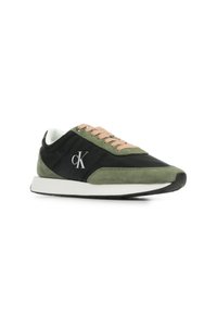 Zapatillas negras y verdes con materiales de ante y tela, con cordones rosas y suela blanca. Logo en plateado en el lateral.