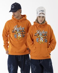 Orange hoodies with graphic prints, featuring cartoon-style characters. One model wears a white beanie, the other a dark cap. Blue jeans displayed.