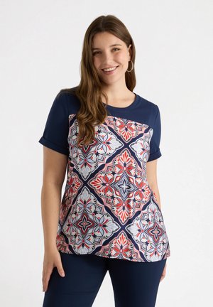 Camiseta azul marino con un frontal estampado con formas geométricas en rojo, blanco y azul. Mangas cortas y cuello redondo.