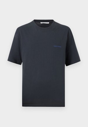 Schwarzes T-Shirt mit kurzen Ärmeln und Rundhalsausschnitt, mit kleinem blauem "Tiger of Sweden"-Logo auf der linken Brust vor einfarbigem Hintergrund.