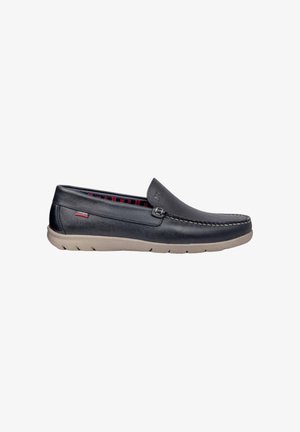 Scarpa slip-on in pelle nera con una texture liscia, suola beige e un rivestimento interno a scacchi rossi in contrasto. Dettagli di cucitura lungo il bordo e branding sottile.