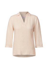Blouse légère rose clair avec un col en V, un col replié et des manches trois-quarts. Tissu texturé avec une coupe décontractée.