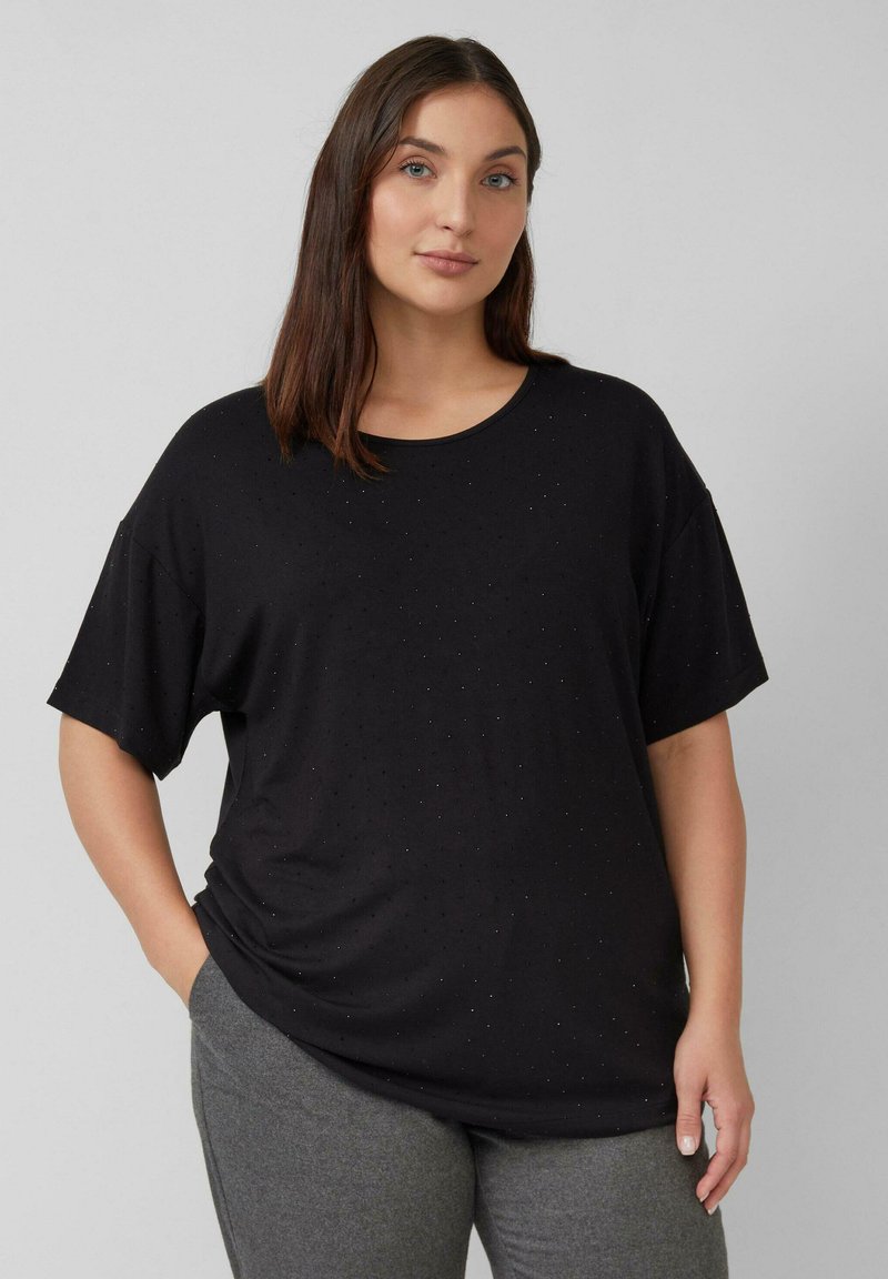 Czarny T-shirt z krótkim rękawem i okrągłym dekoltem, charakteryzujący się miękką teksturą i subtelnym, kropektowym wzorem na tkaninie. Połączony z szarymi spodniami.