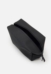 Black pouch made of smooth material with a wide zipper opening, angular shape, and stitched accents along the edges.