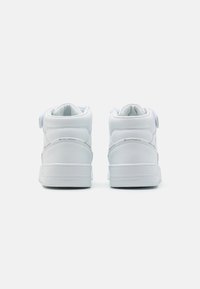 Hvite høye sneakers laget av glatt skinn, med polstret krage, flate snørebånd og en teksturert gummisåle med minimalistisk design.