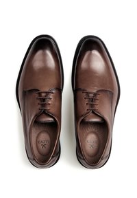 Chaussures habillées en cuir marron avec une finition brillante, bout rond, design à lacets et détails de couture discrets ; l'intérieur présente un estampillage de logo.