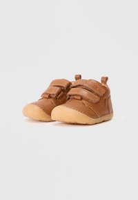 Scarpe per toddler in pelle marrone con cinturini in Velcro, punta arrotondata, suola in gomma e dettagli di cucitura. Piccole linguette sul retro per indossarle facilmente.