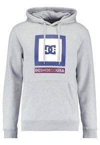 Grå bomullshuvtröja med framficka, med en vit logotyp i en blå fyrkantig kontur och en vinröd etikett på den nedersta bandet.