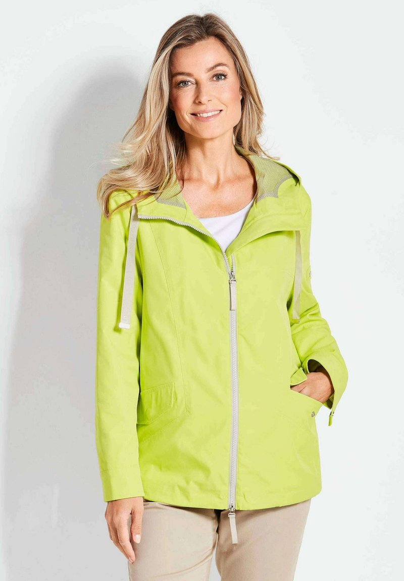 Limonengrüne Zip-Jacke mit Kapuze, ausgestattet mit einem meshgefütterten Kragen und zwei Seitentaschen, aus leichtem, wasserabweisendem Material.