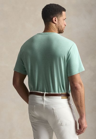 Μπλουζάκι με κοντά μανίκια σε μέντα πράσινο χρώμα με λαιμόκοψη στρογγυλή, συνδυασμένο με λευκό παντελόνι, που διαθέτει καφέ ζώνη και απαλό υφή.