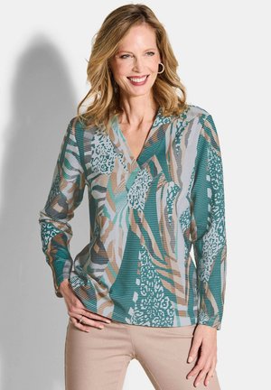 Langarmblouse in teal, met een mix van abstracte patronen, strepen in beige en teal, en een V-halsontwerp. Glad stofoppervlak.