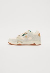 Retro stílusú sneaker bézs és krém velúrból, zöld akcentussal, gumitalppal és texturált dizájn elemekkel.