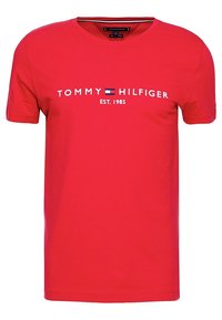 Camiseta de algodón roja con mangas cortas y cuello redondo. Presenta el logo "TOMMY HILFIGER" en acentos blancos y azules, además del texto "EST. 1985".