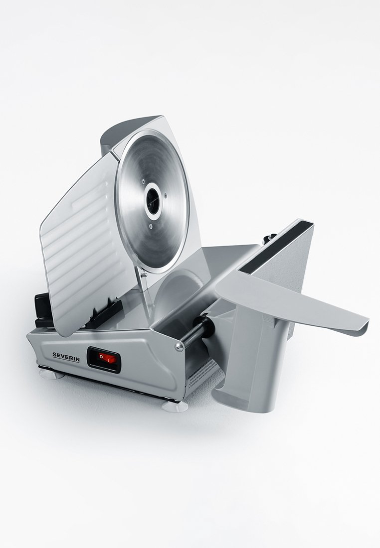 Affettatrice elettrica in metallo argentato con una lama circolare. Presenta una manopola per la regolazione dello spessore, un interruttore di sicurezza e un vassoio laterale per un'affettatura stabile.