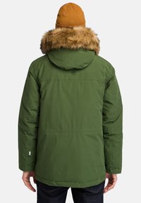 Groene parka jas met een capuchon van nepbont, voorzien van een knoop- en ritssluiting, en een gladde stoftextuur. Ontworpen voor warmte.
