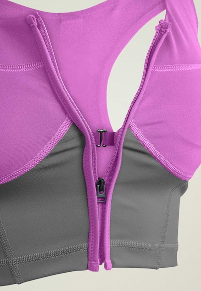 Pink sports bra with a gray base, featuring a front zipper closure and a racerback design. Smooth fabric with contrasting seams.