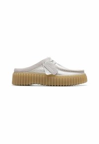 White slip-on shoes with textured fabric, a rubber platform sole, and a light gray suede accent. Features a branded tab on the side.