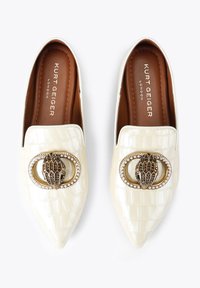 Cremfarbene Schlüpfschuhe aus Kunstleder im Krokodil-Look mit spitzen Zehen und einer dekorativen gold-schwarzen Schnalle, die mit klaren Edelsteinen akzentuiert ist.