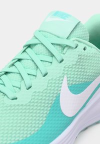  Lichtgroene Nike sportshoe met een bovenkant van gaas, een gestructureerd oppervlak, platte veters en een witte swoosh-logo aan de zijkant.