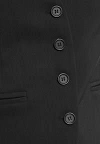 Schwarze maßgeschneiderte Jacke aus glattem Stoff, ausgestattet mit fünf funktionalen runden Knöpfen und zwei Seitentaschen, im eleganten, taillierten Design.