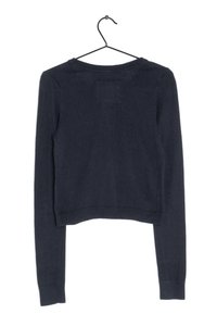 Granatowy, krótki sweter z długimi rękawami, ściągaczami na mankietach i na dole. Miękka dzianina, gładki wzór z małą naszywką z tyłu.