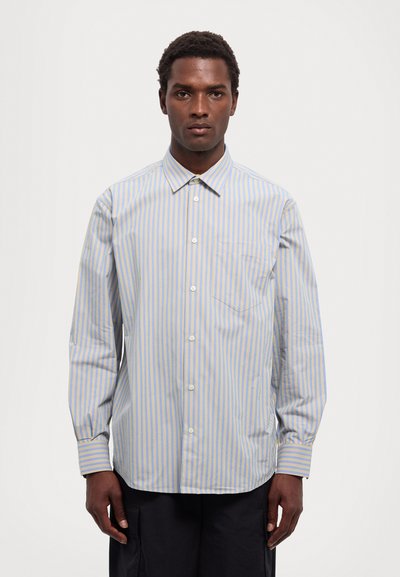 Camicia a maniche lunghe a righe azzurre e gialle con chiusura a bottoni, colletto a punta e una tasca sul petto.