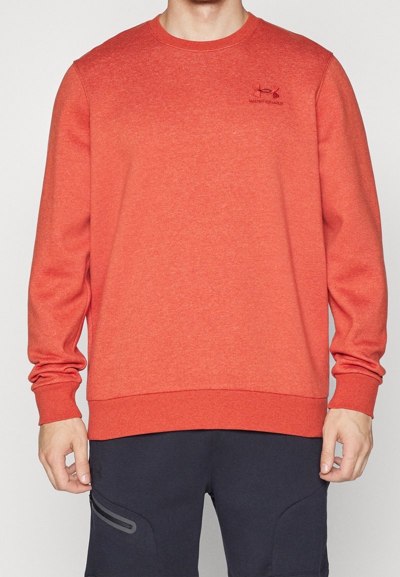 Sudadera de cuello redondo roja, hecha de una tela texturizada con puños y dobladillo de canalé, que presenta un pequeño logo en el pecho.