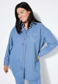 Leren denim overhemd in lichtblauw, met een voorzak met een witte hartsteek, knoopsluiting, lange mouwen en een gebogen zoom.