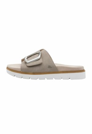 Sandale beige en daim avec semelle en caoutchouc blanc et grande boucle argentée sur la sangle supérieure, vue de côté, sans arrière-plan.