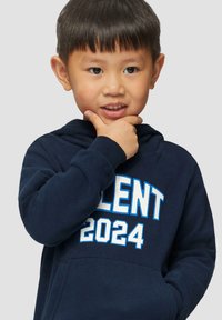 Marineblauwe hoodie met witte en blauwe opdruk "TALENT 2024". Voorzien van een voorzak, verstelbare capuchon en een zachte stoftextuur.