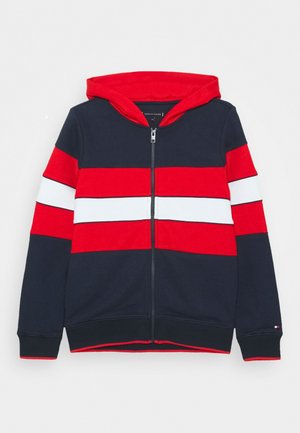 Marineblauer, rot-weißer Kapuzenpullover mit durchgehendem Reißverschluss, roter Kapuze und langen Ärmeln.