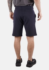 Shorts sportivi blu navy realizzati in tessuto morbido, con una vestibilità rilassata e tasche laterali. Presentano una vita liscia e dettagli di cucitura minimi.
