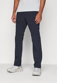 Pantalons zippés navy pour hommes en tissu léger et respirant. Caractéristiques : poches latérales et coupe fuselée pour le confort et la praticité.