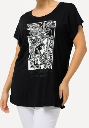Camiseta negra de manga corta con un estampado floral blanco, diseño enmarcado y texto "HAY MUCHAS RAZONES PARA SER FELIZ" en una fuente estilizada.
