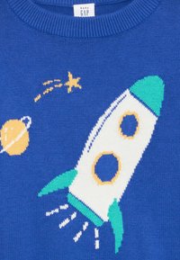Blauwe gebreide trui met een raketontwerp in het wit, groen en geel, vergezeld van een planeet en sterren, gemaakt van zachte, gladde stof.