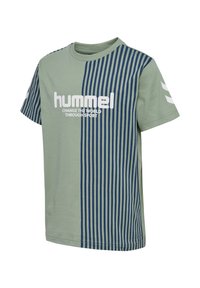 Kortærmet grøn t-shirt med blå lodrette striber på højre side og ærme, hvidt "hummel"-logo og tekst "FORANDR VERDEN GENNEM SPORT" på fronten.