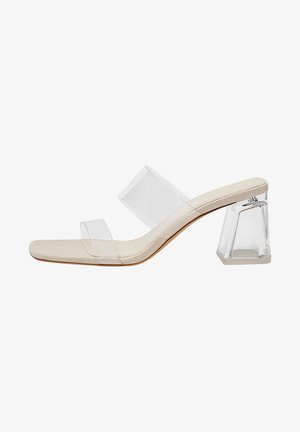 Sandalia mule beige de punta abierta con dos tiras transparentes y un tacón bloque claro y grueso.