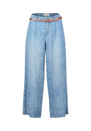 Hellblaue, weit geschnittene Jeanshosen mit weißem Paisley-Bandana-Muster und einem schmalen braunen Ledergürtel in der Taille.