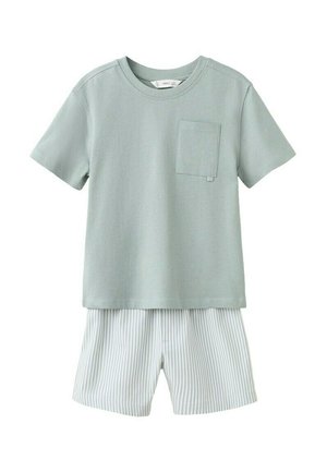 Zelená košile krátkého rukávu se sýpku na hrudi, doplněná bílými šortkami s tenkými svislými šedými pruhy.