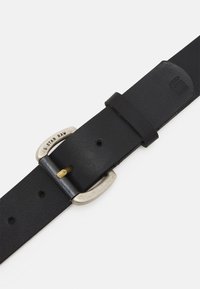 Cintura in pelle nera con fibbia in metallo di tonalità argento, caratterizzata da un design semplice e un piccolo accento dorato sulla fibbia per la chiusura.