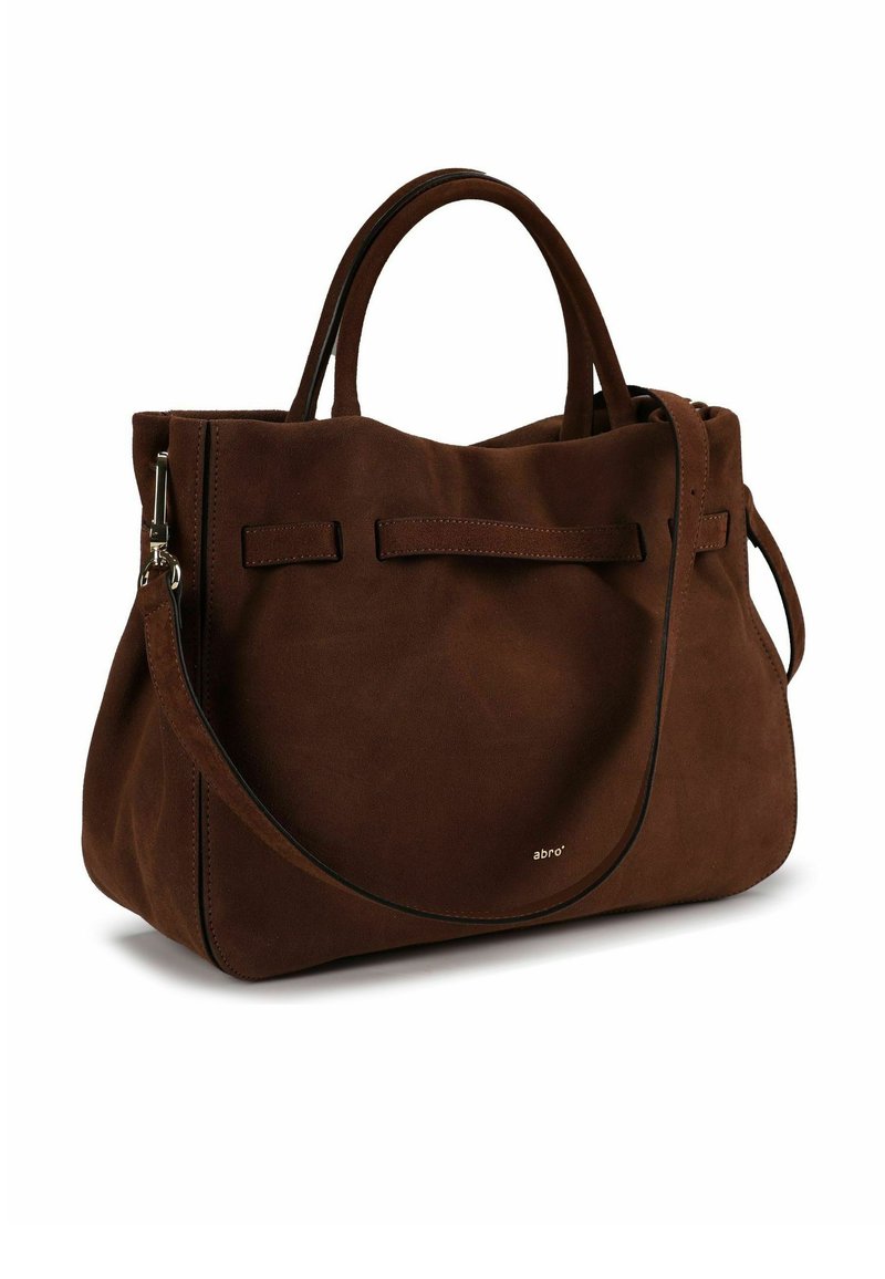 Sac cabas en daim marron avec deux poignées courtes et une bandoulière détachable. Il présente un design simple et un logo de marque subtil sur le côté.