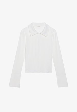 Blusa branca de manga longa com gola, apresentando um fecho de correr à frente, textura canelada e punhos amplos. Design simples com um acabamento limpo.